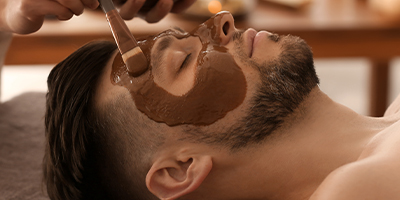 A man receiving the Pevonia Chocolate Indulgence Mask treatment.