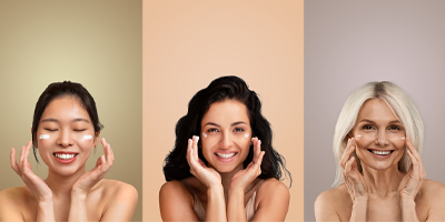 Three women on different colored backdrops smiling using Pevonia Moisturizers.