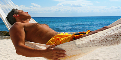 A man sunbathing in a canopy.
