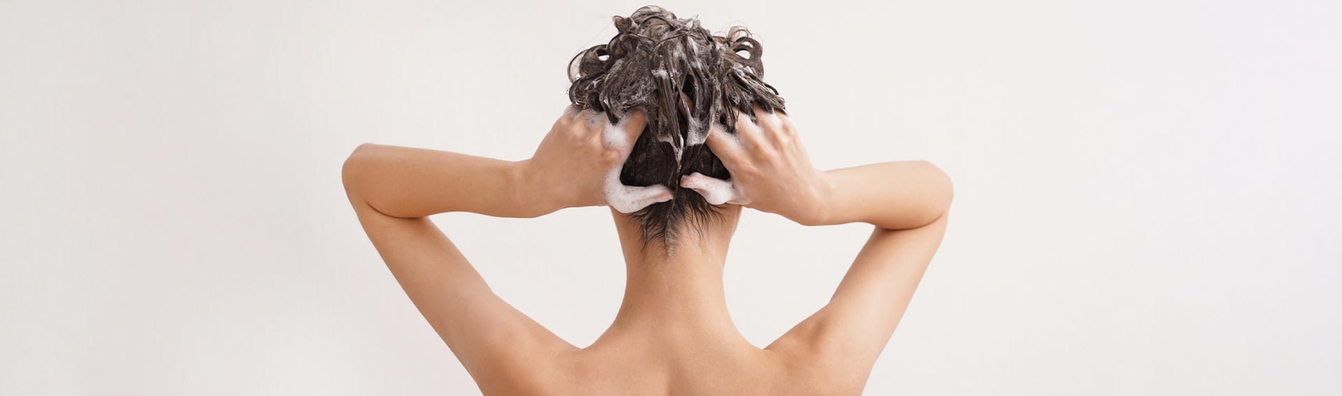 A woman washing her hair with Pevonia's Hair Energize Products.