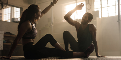 A couple high-fiving after an intense workout session.